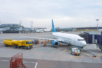 Passenger plane at the telescope of the airport terminal building, for maintenance and refueling...