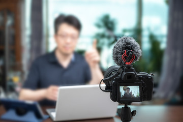 Online lecture concept. Asian middle-aged man giving online lectures at home.