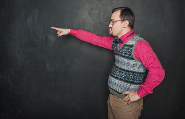 Angry teacher pointing out on blackboard background