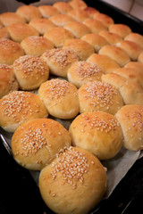 home made fresh baked buns with sesame and butter Delicious  cakes on baking tray for oven ready to eat,  Shallow depth of field, top view 