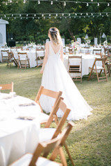 The bride poses showing her back. As the sun goes down, at the wedding venue.