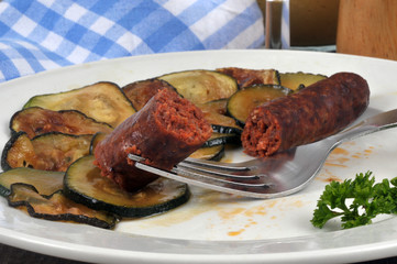 Rondelles de courgette et merguez servies dans une assiette en gros plan