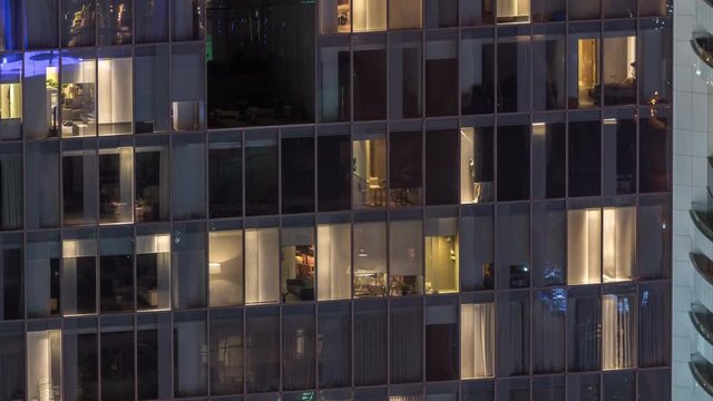 Night view of office and apartment building timelapse. High rise skyscraper with blinking windows with people moving inside. Aerial view from above