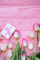 Obraz na płótnie Canvas Wooden pink background and tulips with gift box. Flat lay. Conception holiday, March 8, Mother's Day.