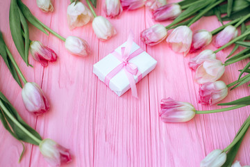 Wooden pink background and tulips with gift box. Flat lay. Conception holiday, March 8, Mother's Day.