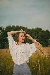 Portrait of a girl in a vintage dress on nature background. A girl with long hair in a field on a...