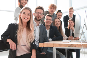 young business woman sitting in front of a big business team
