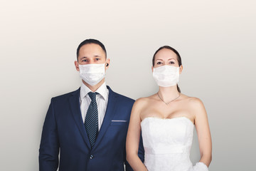 Wedding during the coronavirus period. Bride and groom in protective medical masks