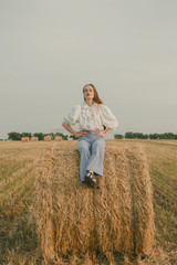 Portrait of a girl in a vintage dress on nature background. A girl with long hair in a field on a summer sunny day. Fashion vintage dress.