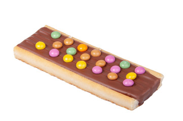 Chocolate bar snack with colorful drops or dragee isolated on the white