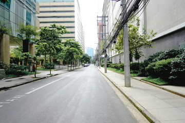 Fototapeta na wymiar Empty street in Vila Olimpia, during coronavirus outbreak, Sao Paulo, Brazil with some cyclists - March 2020