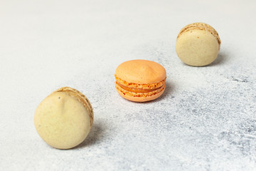 Mixed of Colorful Macarons cake on white concrete background with copy space. Green and orange french macaroons.