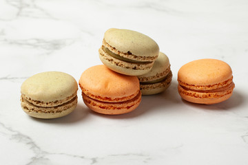 Mixed of Colorful Macarons cake on marble background with copy space. Green and orange french macaroons.