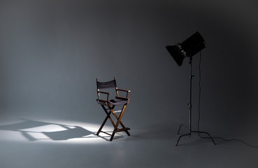 Empty photo studio with lighting equipment. Space for text. Vacant directors chair. The concept of...