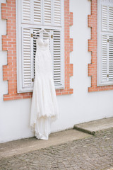 A white wedding dress hanged on the hanger. Buying a wedding dress.