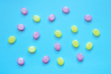 Multicolored candy on a colored background. Flat lay