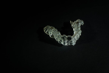 invisible dental appliance insulated on a black background with space on the left for text. Concept dental corrector