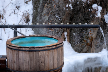 Hot springs georhemal water in mountains in winter. Vat with hot geothermal water in Medeo gorge, Gorelnik hot springs, Almaty, Kazakhstan.