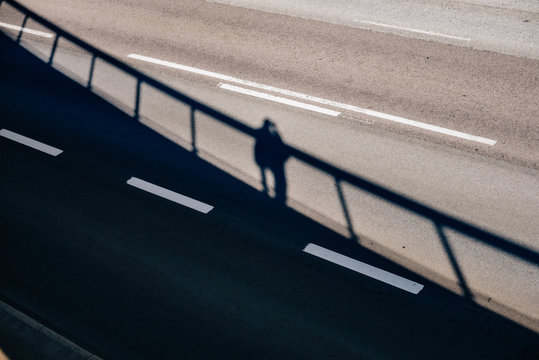 Mann steht auf einer Br&uuml;cke mit seinem Schatten