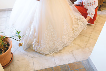 Fototapeta na wymiar bridesmaid helping bride with dress