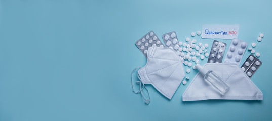 Quarantine 2020 phrase text on a blue background with pills, sanitizer and protective masks