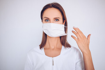 Close up portrait of beautiful young european woman doctor nurse wearing protective mask corona virus prevention. Free space for text mockup banner. Avoid contaminating Corona virus Covid-19 concept