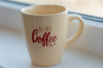 light brown coffee cup with lettering on white background
