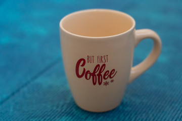 light brown coffee cup with lettering on blue background