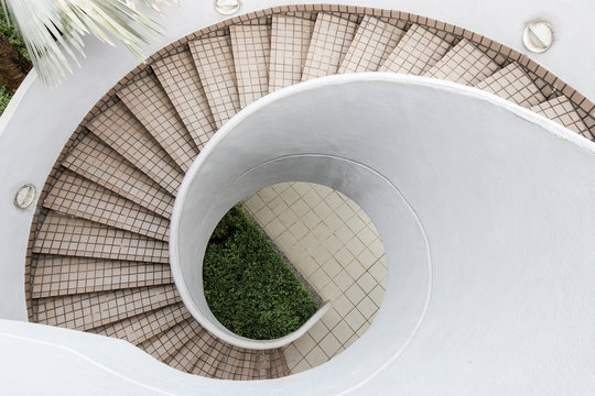 An empty outdoor spiral staircase with tile.