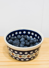 Arándanos en un bol sobre una mesa en vertical