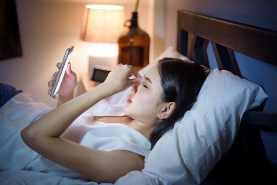 Woman is feeling eye pain when using smart phone at night