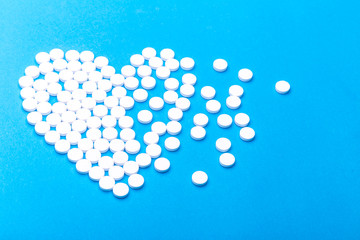 Heart of pills on a blue background.