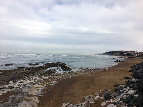 Waves and rocks on wet beach