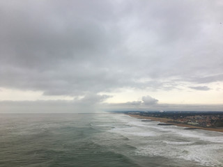 View of a shore, agitated ocean and cloudy sky