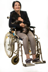Cheerful woman in wheelchair with little dog