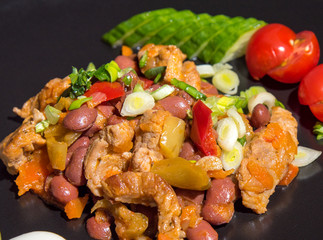 Roasted meat with vegetables and beans top view