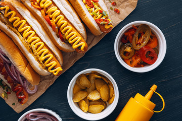 American hot dog with ingredients on a dark wooden background