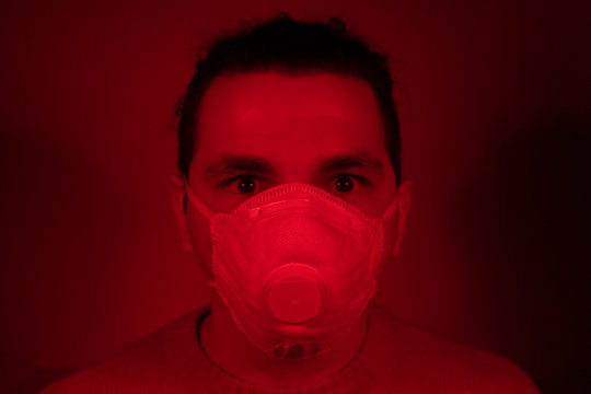 White Caucasian Italian Man In A Red Room With White Mask During The Apocalyptic Times Of Corona Virus Outbreak