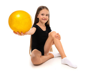 gymnast girl sitting on the floor with gymnastic ball on a white background with copy space