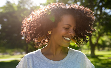 Laughing young woman twirling her hair on a sunny day