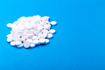 A pile of pills on a blue background.
