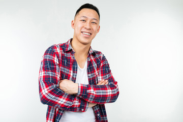 Confident Asian man in a plaid shirt wide open on a white studio background with copy space