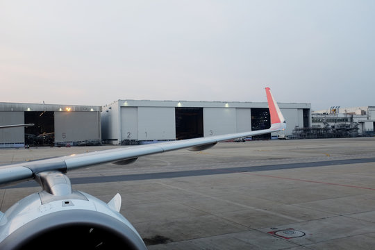 Parked aircraft near the hangar. Cargo plane on the airfield. Commercial air freight. Sunset spotting at the airport. - Image