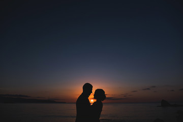 Silhouettes of lovely couple man and woman In beutiful Nature sunset. Couple love concept.