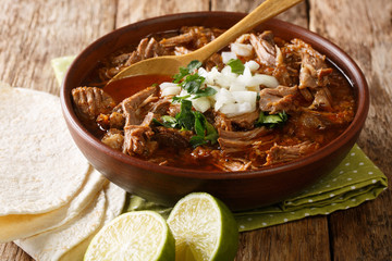 Mexican dish of Birria de Res from slowly stewed beef close-up in a bowl on the table. horizontal