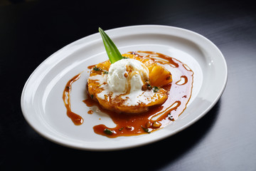 Pineapple with syrup and ice cream on top.
