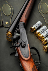 Classic trigger double-barreled hunting rifle on a green background. Smooth-bore hunting rifle open...