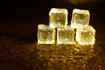 ice cubes on a reflections yellow light.