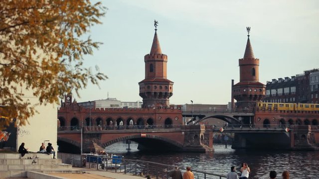 Two yellow trains are passing on the  famous Oberbaum Bridge in Berlin.