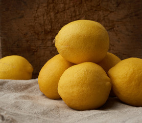 stack of yellow round lemons on a gray textile napkin